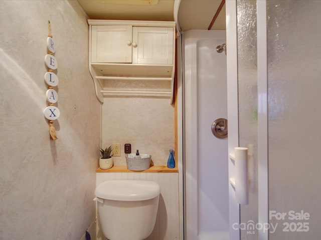 bathroom featuring toilet and walk in shower