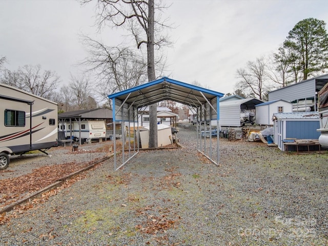 view of yard with a detached carport and gravel driveway