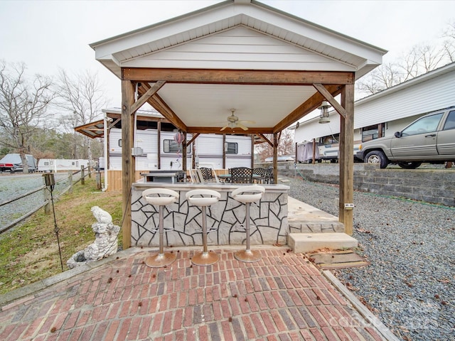 view of patio / terrace featuring ceiling fan, outdoor dry bar, a gazebo, and fence