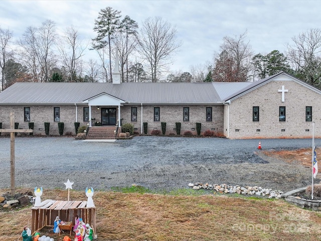 ranch-style home featuring crawl space, metal roof, and brick siding