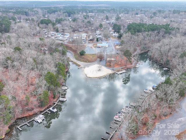 aerial view with a water view and a forest view