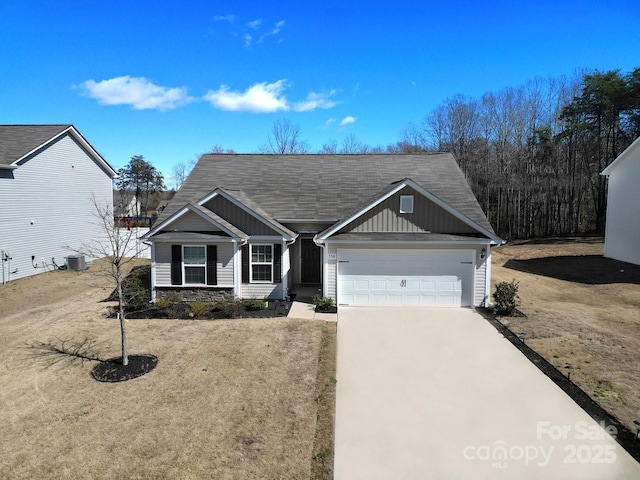 view of front of home featuring driveway, a garage, stone siding, central air condition unit, and board and batten siding