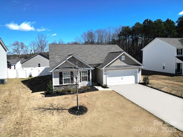 view of front of property featuring central air condition unit, a garage, fence, driveway, and board and batten siding