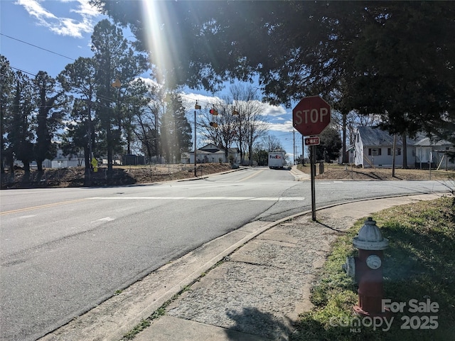 view of road featuring sidewalks, traffic signs, and curbs