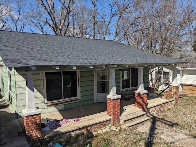 bungalow-style house with a porch and roof with shingles