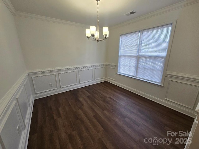 unfurnished dining area featuring a chandelier, a wainscoted wall, dark wood-type flooring, visible vents, and ornamental molding