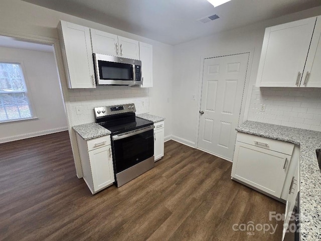 kitchen featuring visible vents, white cabinets, dark wood-style floors, appliances with stainless steel finishes, and light stone counters
