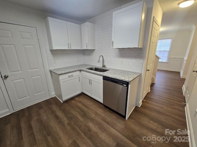 kitchen featuring dark wood-style floors, dishwasher, a sink, and light stone countertops