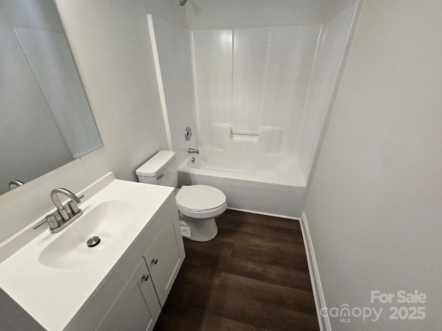 bathroom with toilet, bathtub / shower combination, wood finished floors, and vanity
