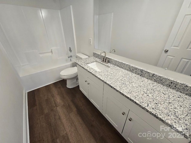 full bath featuring washtub / shower combination, vanity, toilet, and wood finished floors