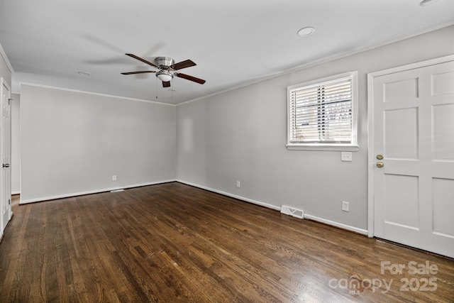 spare room featuring dark wood-style floors, visible vents, and crown molding