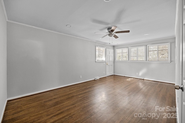 empty room with crown molding, dark wood finished floors, and ceiling fan