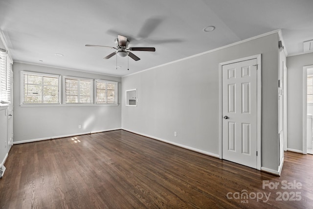 spare room featuring baseboards, attic access, ornamental molding, and wood finished floors