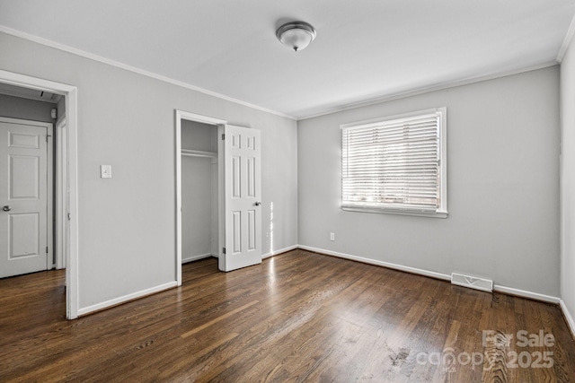 unfurnished bedroom with visible vents, crown molding, baseboards, and wood finished floors