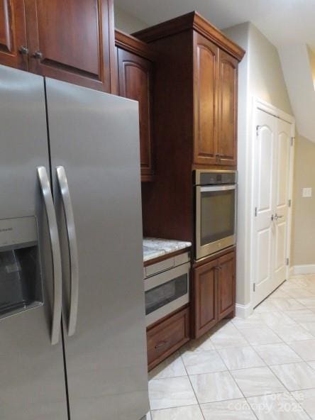 kitchen with light countertops, light tile patterned flooring, baseboards, and stainless steel appliances