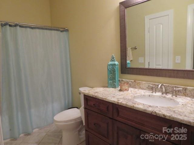 bathroom featuring a shower with curtain, toilet, vanity, and tile patterned flooring