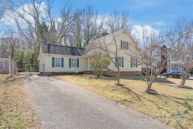 view of front facade featuring a gate, aphalt driveway, a front yard, crawl space, and a chimney