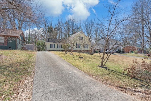 view of front of house featuring gravel driveway and a front lawn