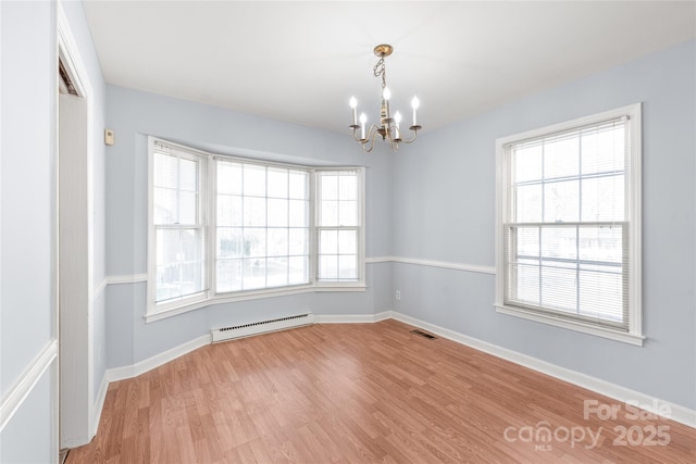 spare room with baseboards, visible vents, light wood-style flooring, a notable chandelier, and baseboard heating