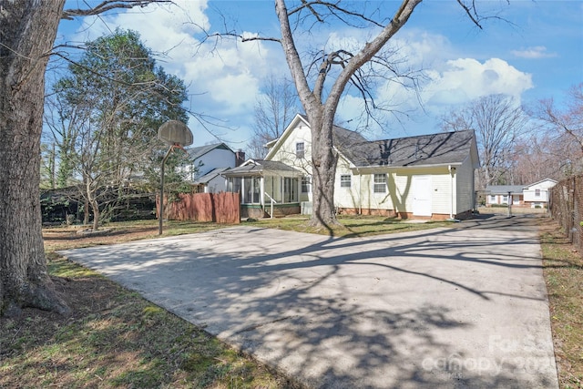 view of front of house with concrete driveway and fence