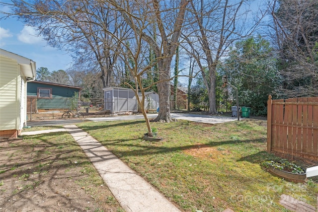 view of yard with an outbuilding, a storage unit, and fence