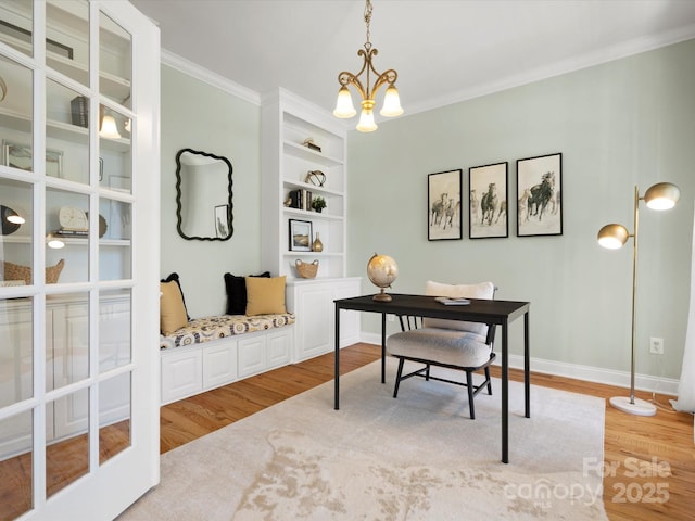 office area featuring a notable chandelier, built in shelves, light wood-style flooring, baseboards, and ornamental molding
