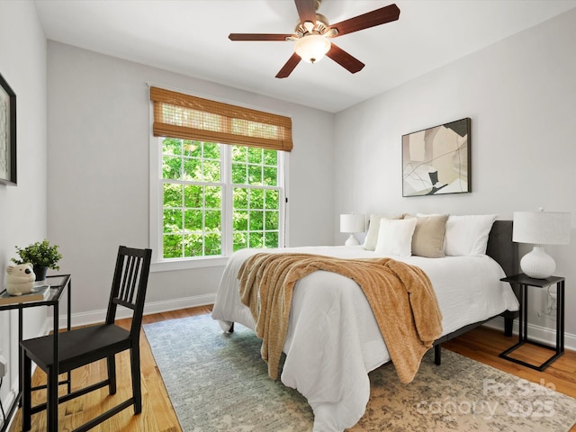 bedroom featuring baseboards, a ceiling fan, and wood finished floors