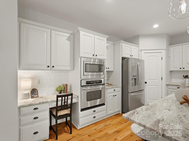 kitchen featuring decorative backsplash, light wood-type flooring, recessed lighting, white cabinets, and stainless steel appliances