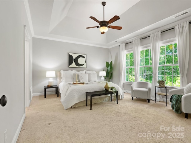 bedroom featuring a ceiling fan, visible vents, baseboards, carpet, and a tray ceiling