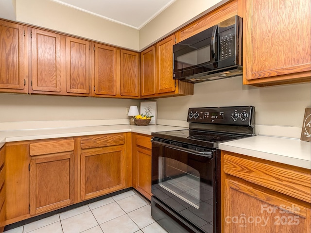 kitchen featuring brown cabinets, crown molding, light tile patterned floors, light countertops, and black appliances