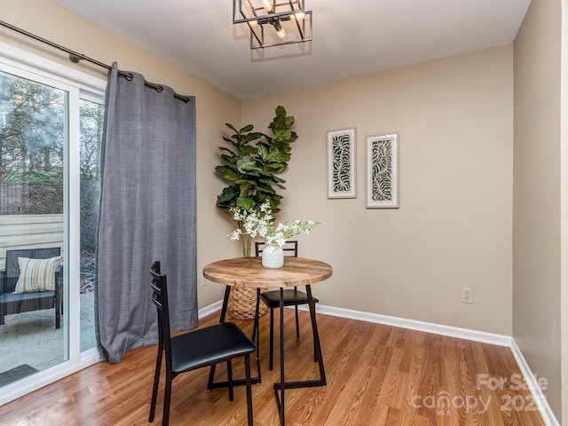 dining room featuring a chandelier, baseboards, and wood finished floors