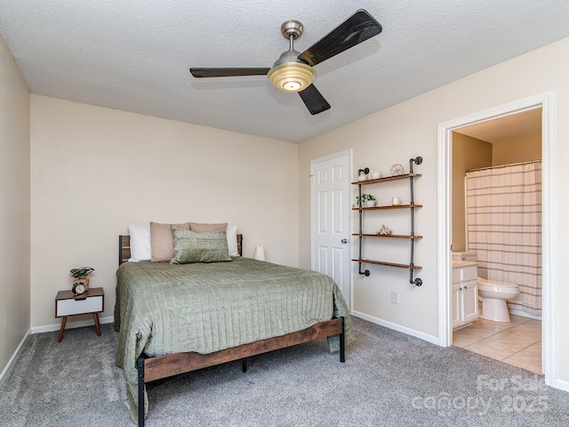 bedroom featuring baseboards, light carpet, a textured ceiling, and ensuite bath