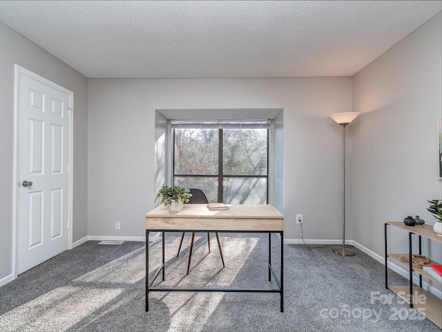 office space with a textured ceiling, carpet floors, and baseboards