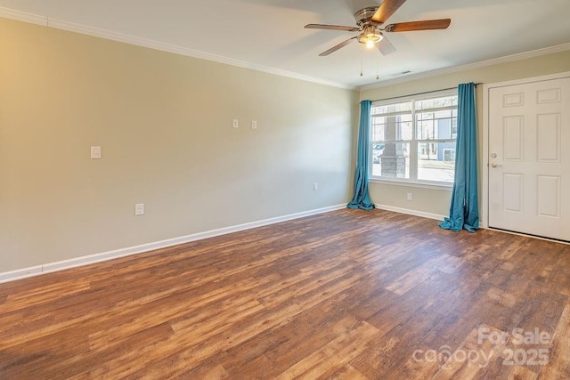 spare room featuring ceiling fan, wood finished floors, visible vents, baseboards, and crown molding