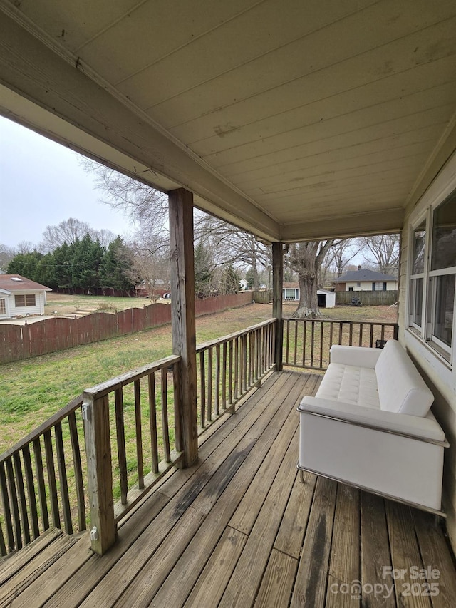 deck with a yard and fence