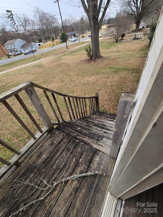 wooden terrace featuring a lawn