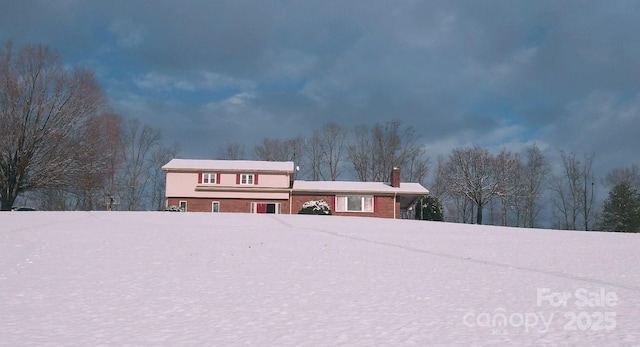 tri-level home featuring brick siding and a chimney