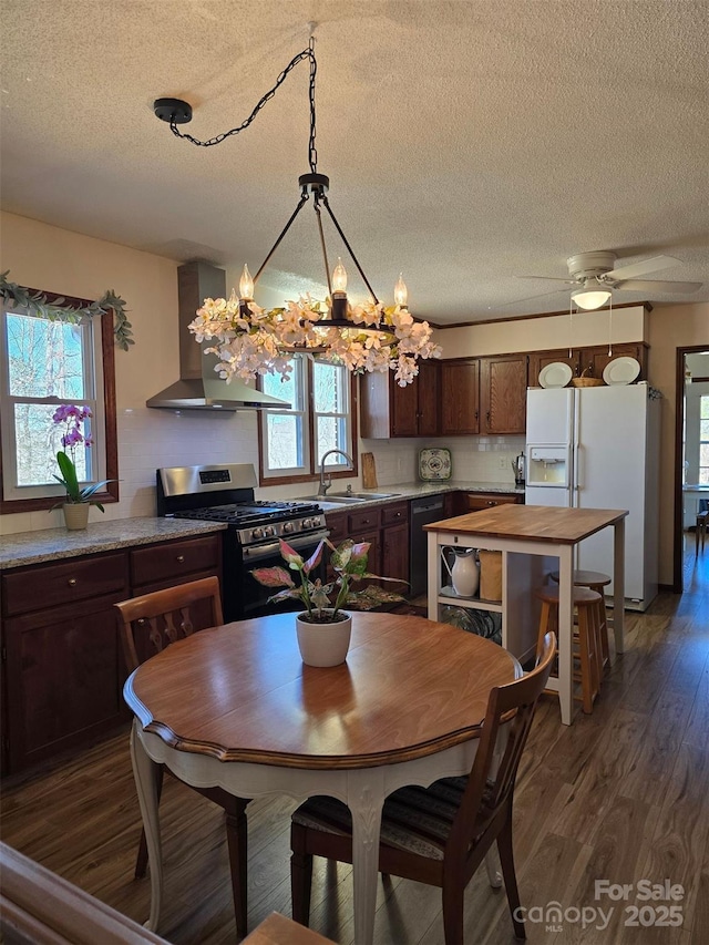 dining space featuring a chandelier, dark wood-style flooring, a healthy amount of sunlight, and a textured ceiling