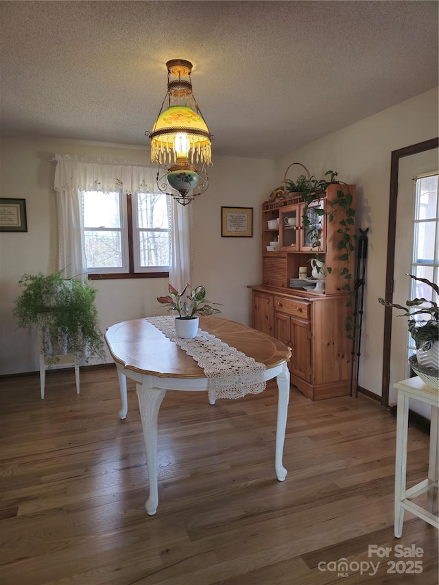 dining room with a textured ceiling and light wood-type flooring