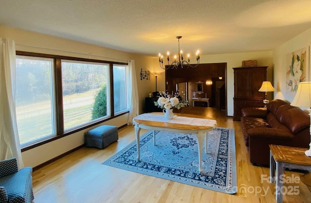 living area featuring an inviting chandelier, a textured ceiling, and wood finished floors