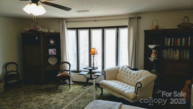 sitting room featuring carpet floors, a ceiling fan, visible vents, and a textured ceiling