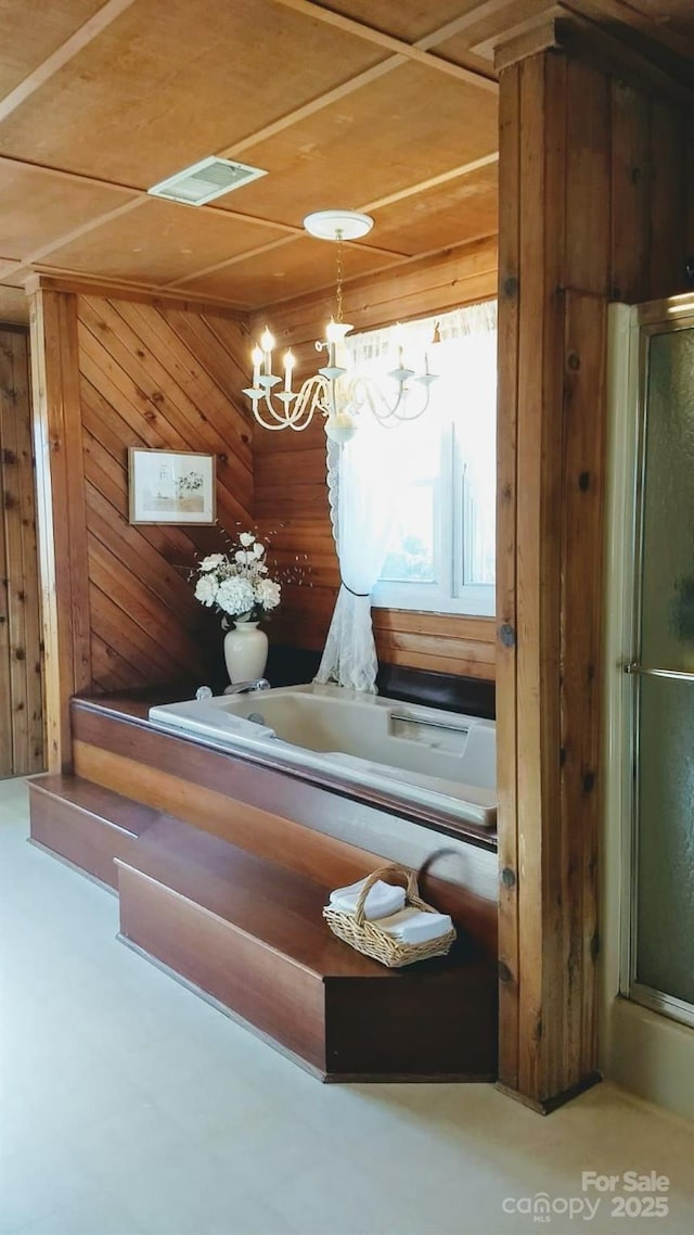 interior space featuring a notable chandelier, visible vents, and wooden walls