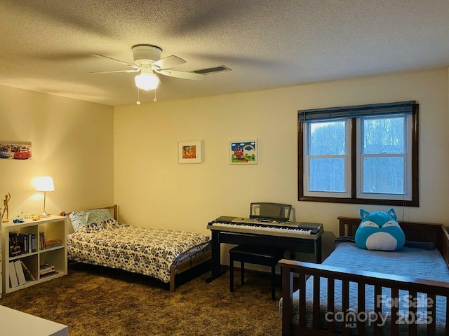 bedroom with carpet floors, a ceiling fan, visible vents, and a textured ceiling