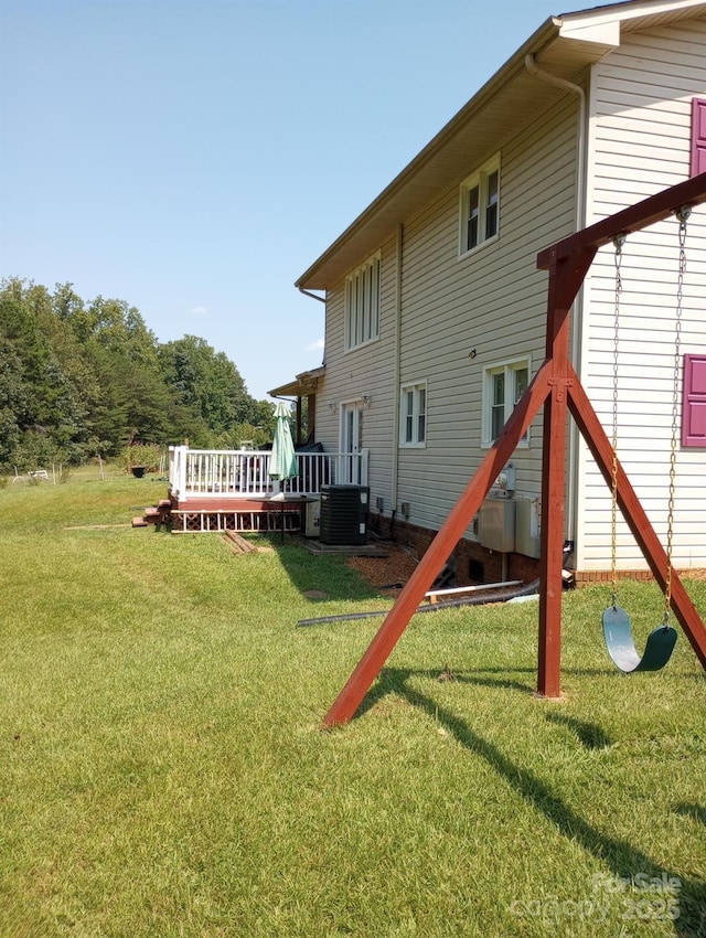 back of house with central AC, a yard, and a wooden deck