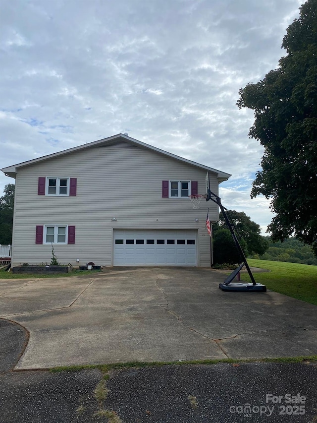 view of property exterior with a garage and driveway