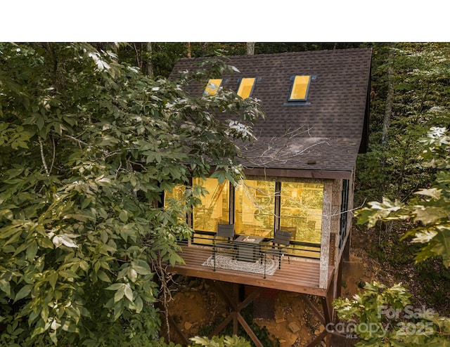 back of property featuring a shingled roof