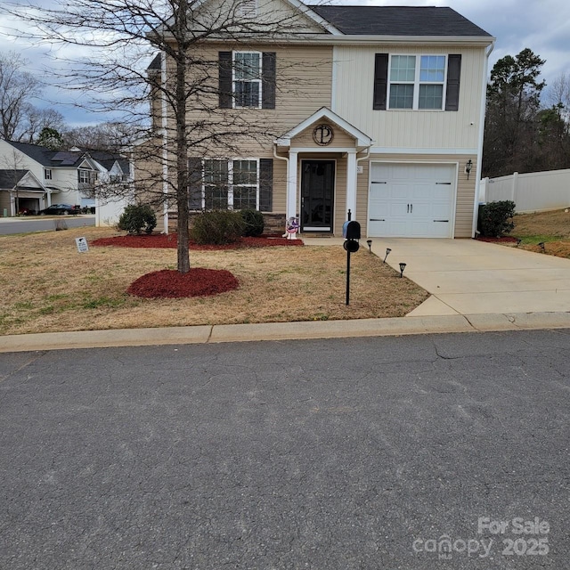 traditional home with a garage, driveway, and fence