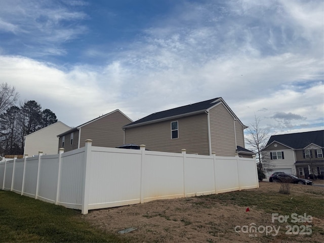 view of side of home featuring fence