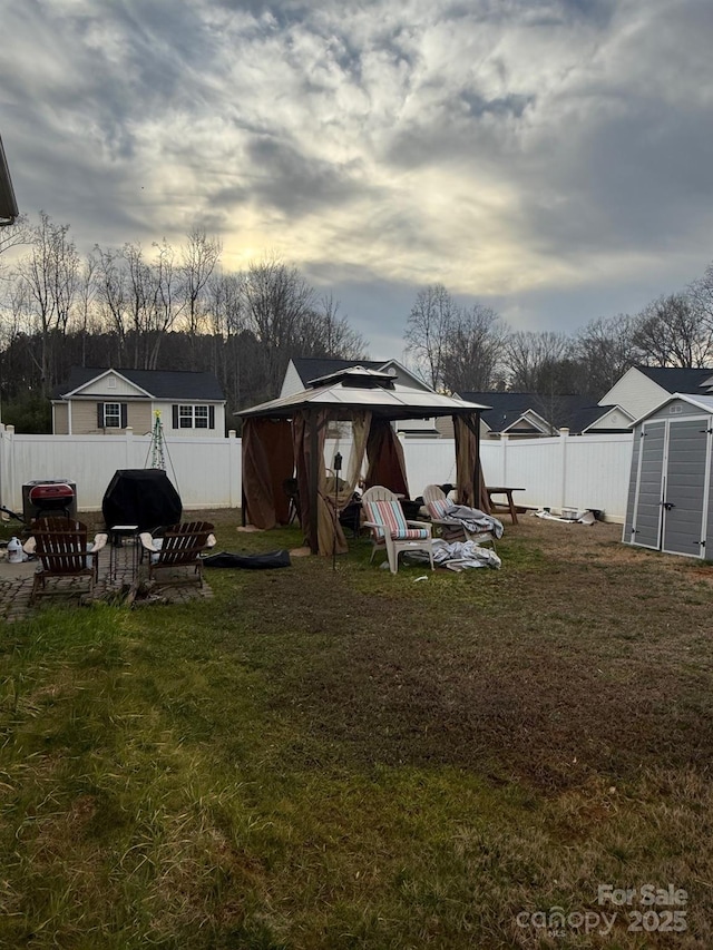 exterior space featuring a storage shed, a yard, an outbuilding, and a fenced backyard