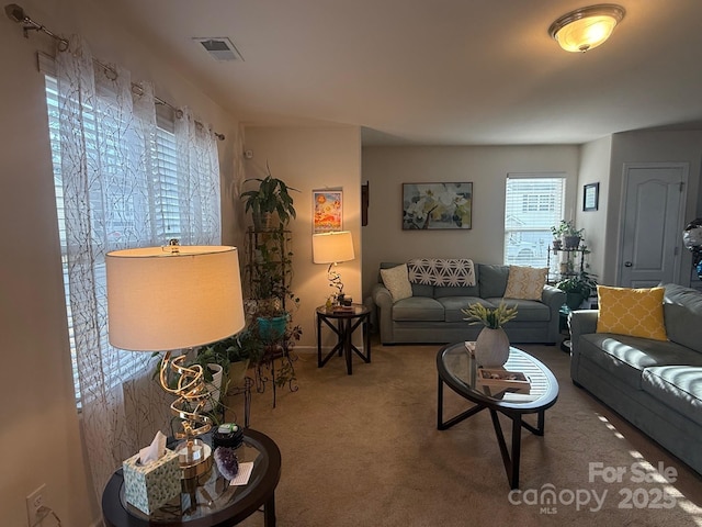 living area featuring carpet floors and visible vents